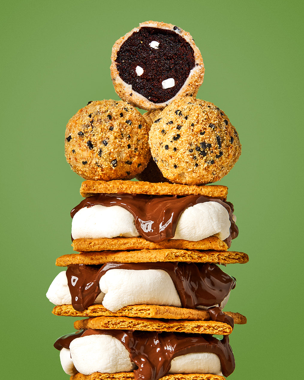 A stack of 3 gooey s'mores with three limited-time s'mores cake truffles nestled at the top.