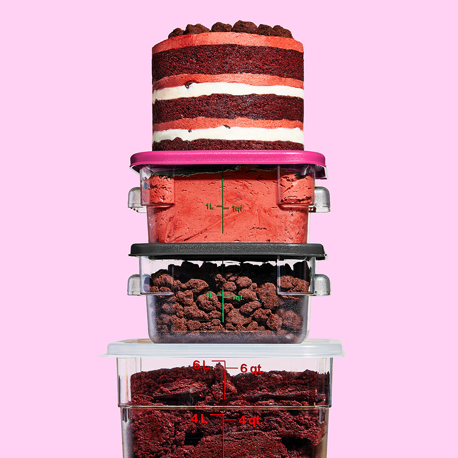 3 containers stacked on top of each other containing the frosting and fillings in the red velvet cake layers, with a whole cake sitting on top 