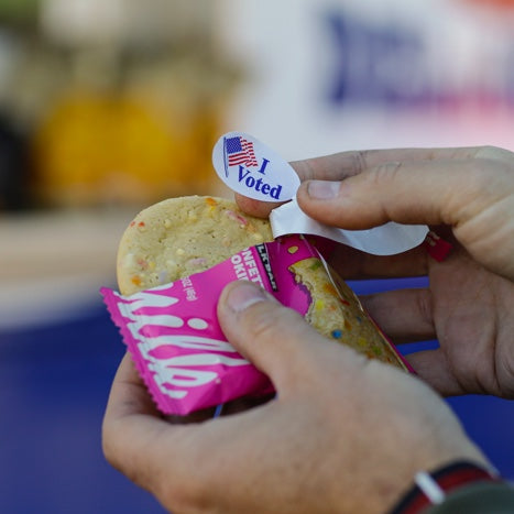 two hands tearing open the packaging on a grocery store Confetti Cookie wrapper..