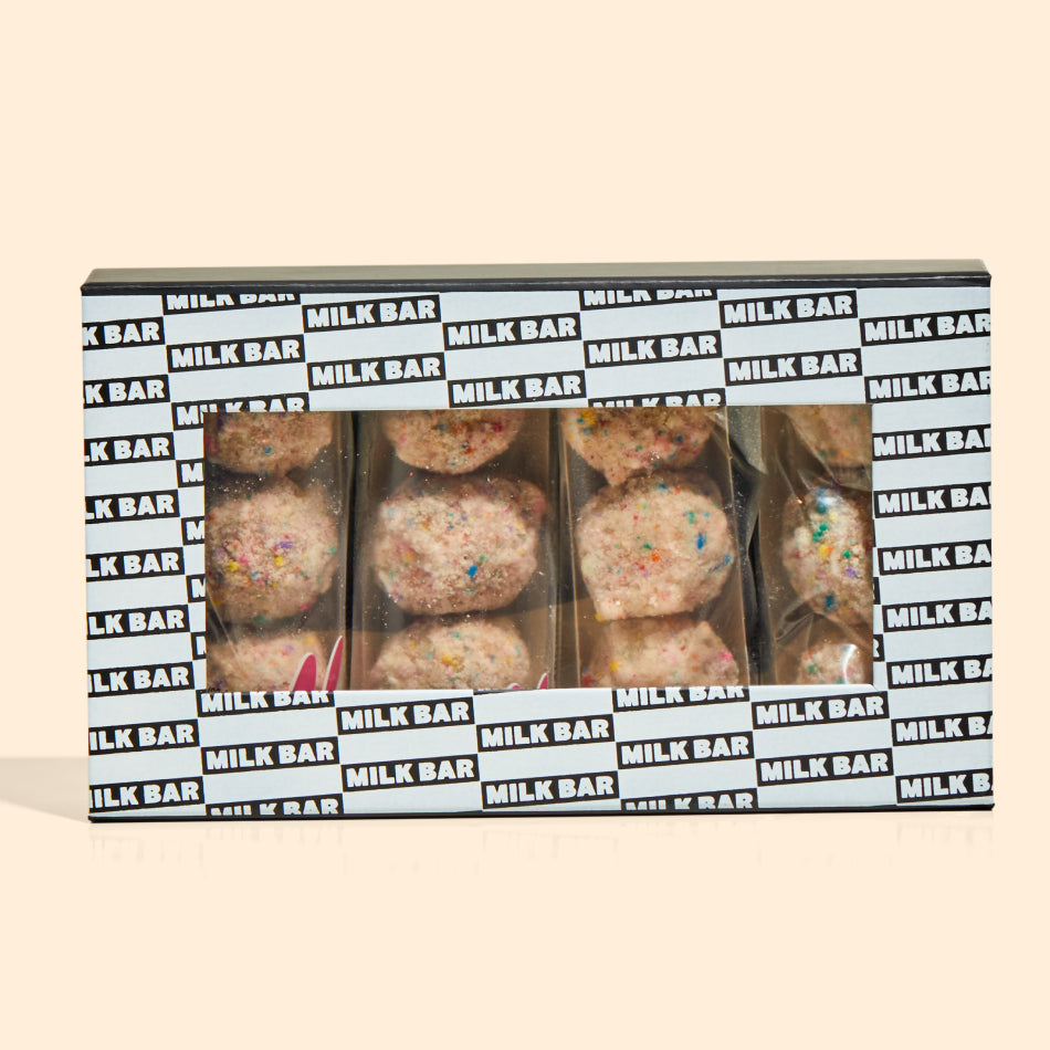 Overhead view of the individual b'day truffle 3-packs inside of a branded giftable milk bar box.