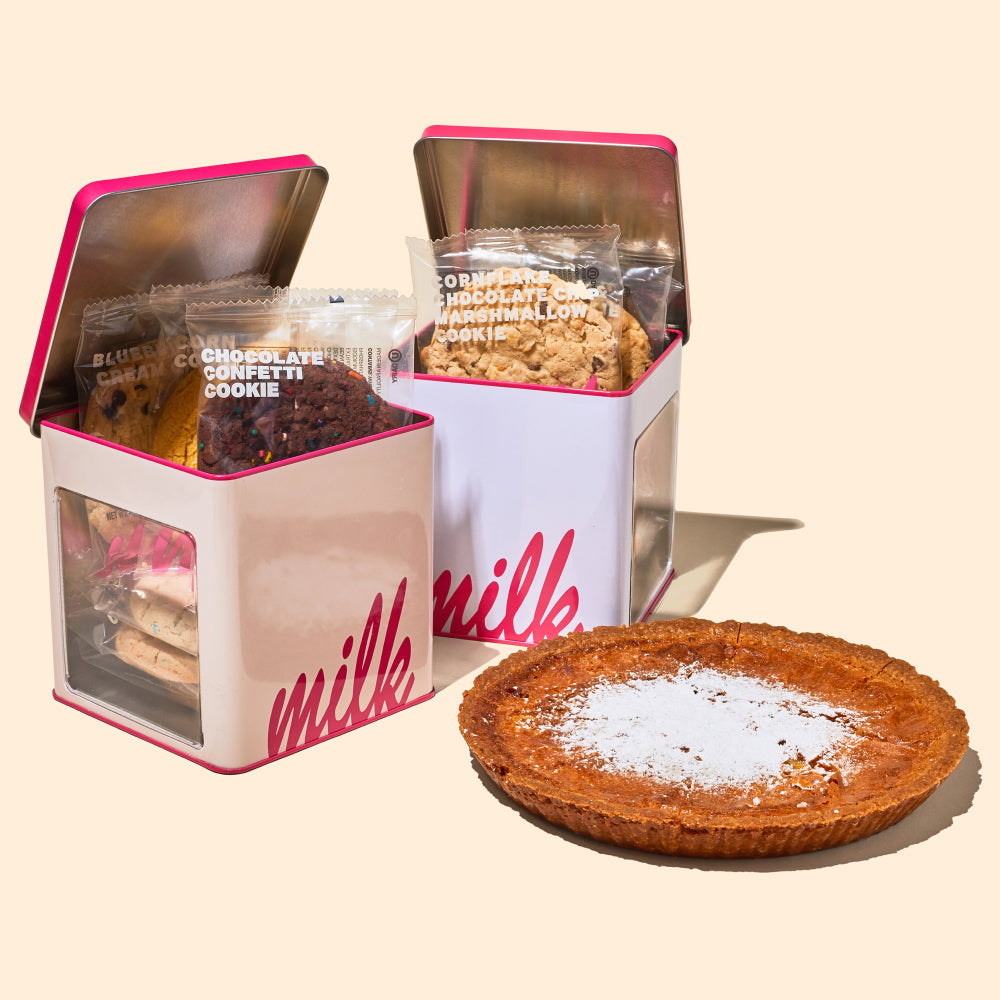 A whole Milk Bar Pie beside 2 Assorted Cookie Tins