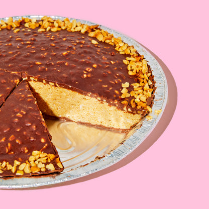 A whole peanut butter crunch pie with a slice removed from the pan.