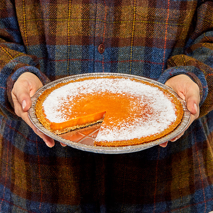 A human holding a whole Pumpkin Milk Bar Pie.
