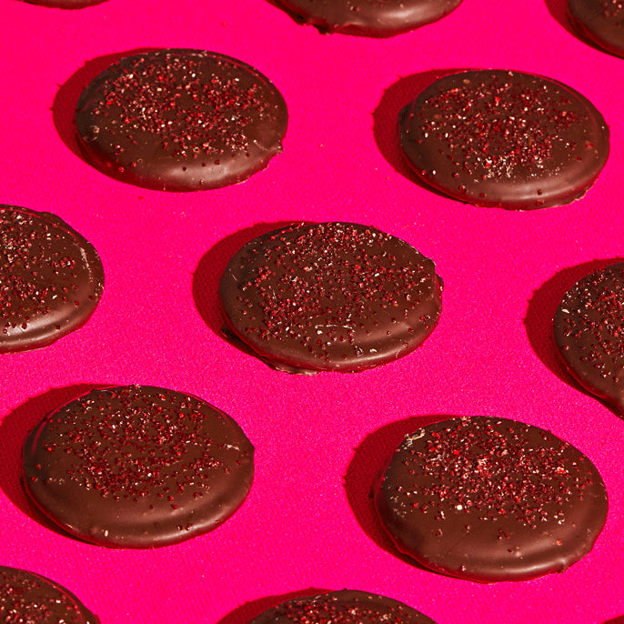 A GIF of evenly spread mini chocolate-covered strawberry snaps rotating side to side, with the center snap disappearing after 4 bites being removed.