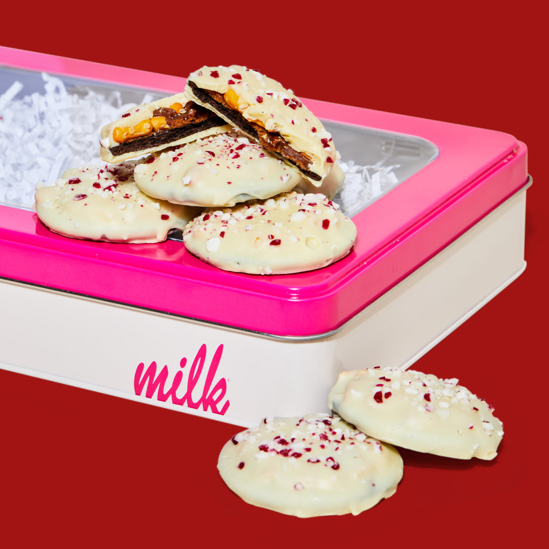 A stack of mini peppermint bark snaps on a milk bar branded giftable tin.