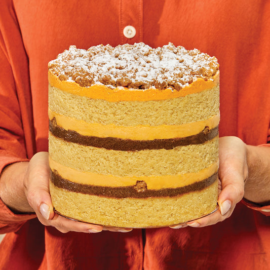 A human holding a whole 6" pumpkin coffee-cake cake