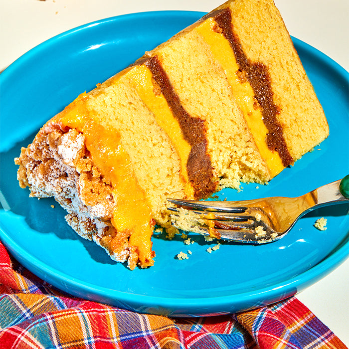 A close up shot of a slice of pumpkin coffee-cake cake on a blue plate.