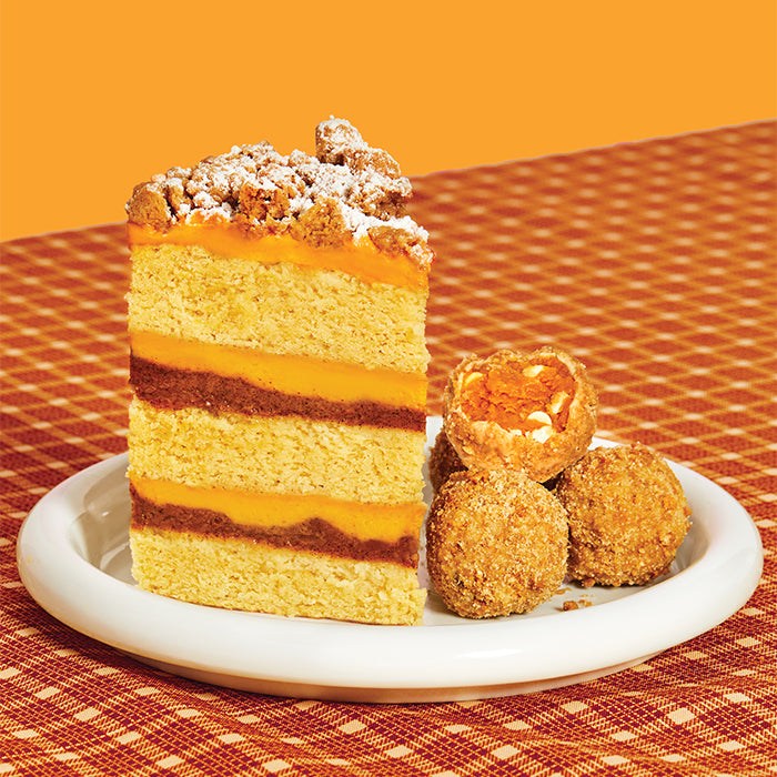 A stack of pumpkin coffee-cake cake truffles next to a slice of pumpkin coffee-cake cake.