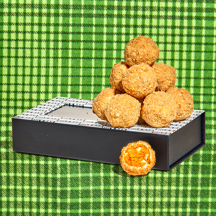 side view of a pumpkin coffee cake truffle dozen box with truffles sitting on top.