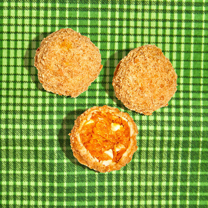 overhead view of 3 pumpkin coffee cake truffles, with one truffle sliced in half.