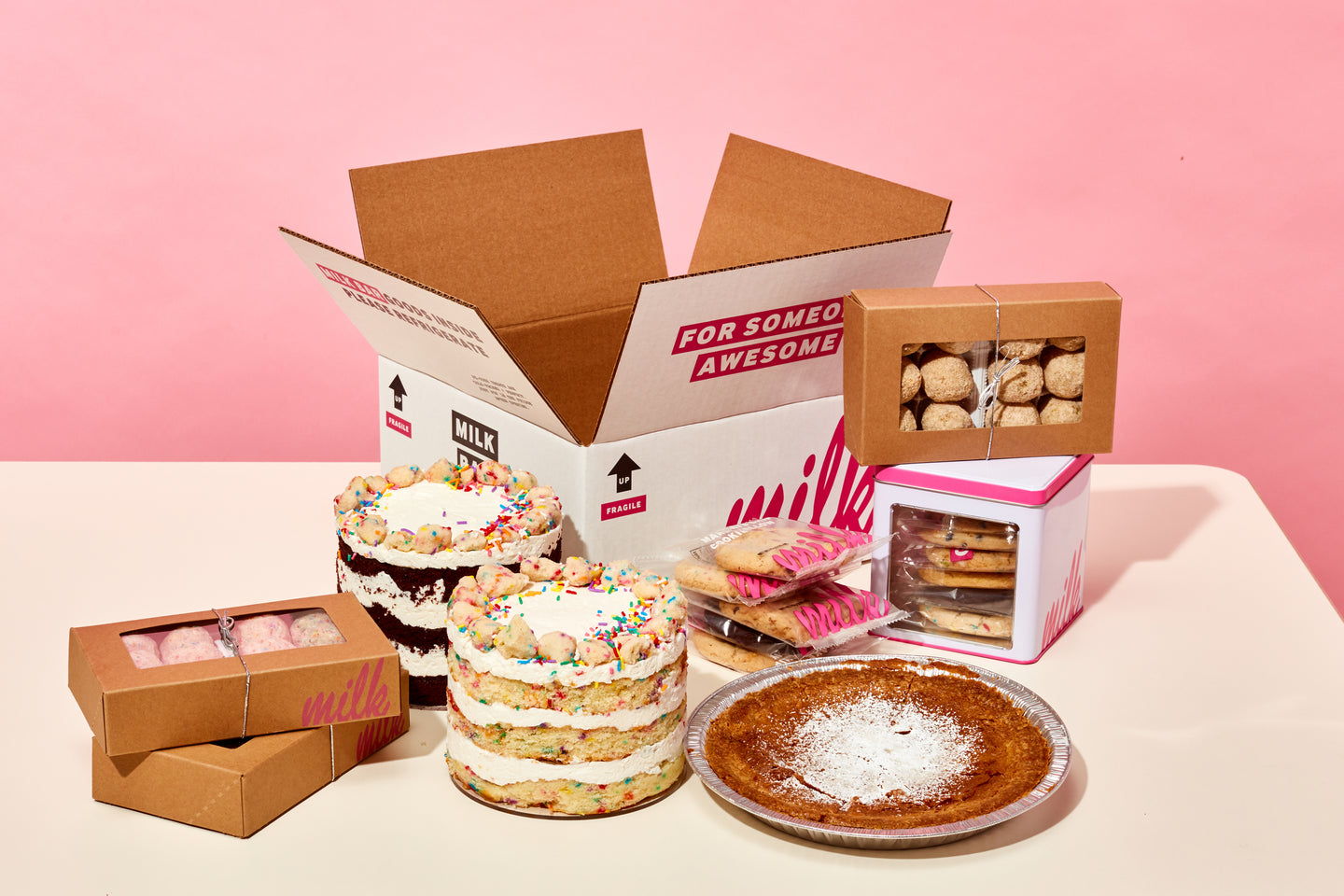 A mix of Milk Bar Classic products on a table, such as the Milk Bar Pie, 6