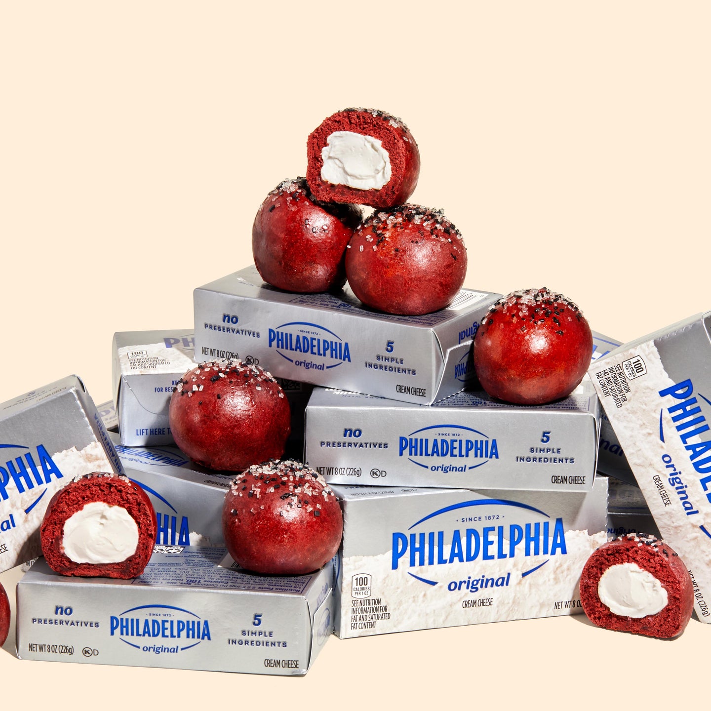 A stack of Philadephia Cream Cheese blocks with Mini Red Velvet Philly Bagel Bombs stacked on top.