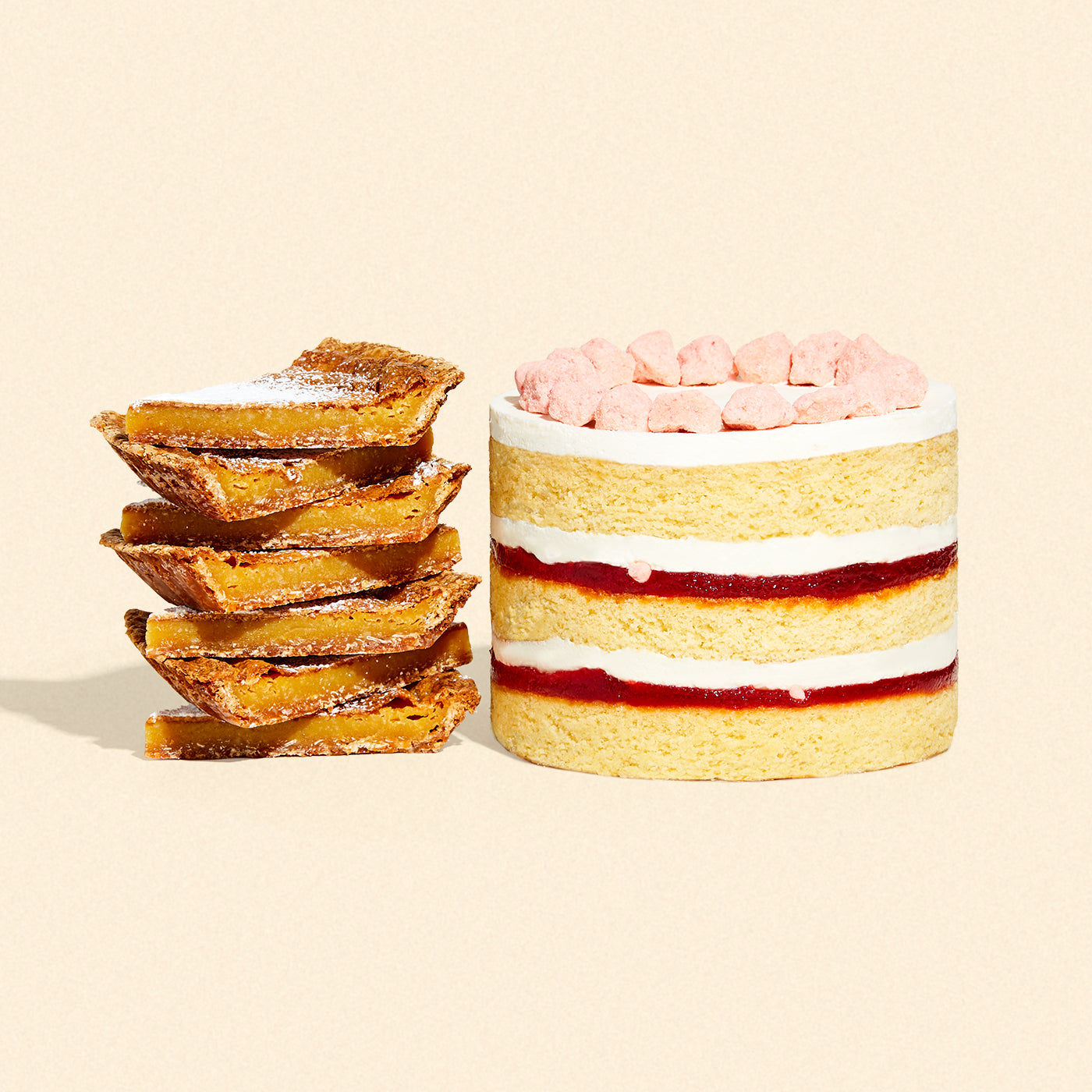 A whole 6 inch strawberry shortcake cake beside a stack of milk bar pie slices.