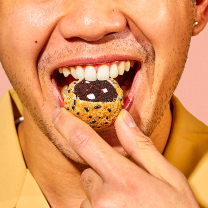 close up view of a person's face while taking a bite into a s'mores cake truffle