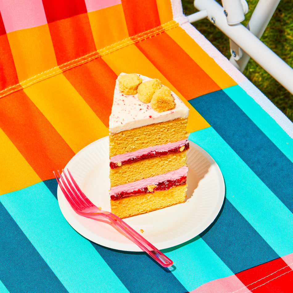 A slice of Strawberry Corn Cake outdoors on a vibrant picnic chair.
