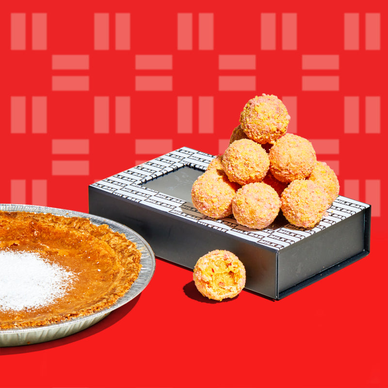 A whole milk bar pie sitting next to a stack of strawberry corn cake truffles.