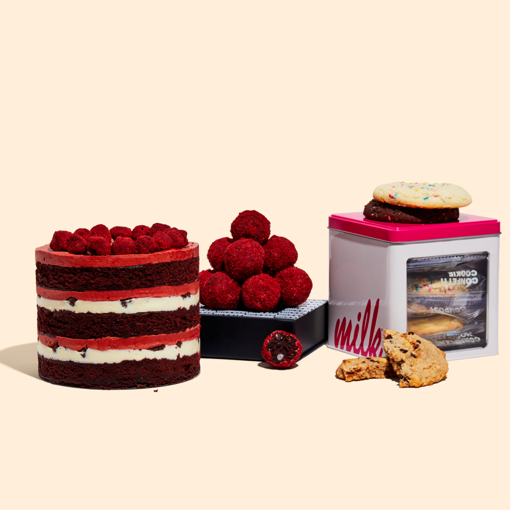An assorted cookies tin, a Red Velvet Cheesecake Truffle dozen box, and a 6" Red Velvet Cheesecake Cake.