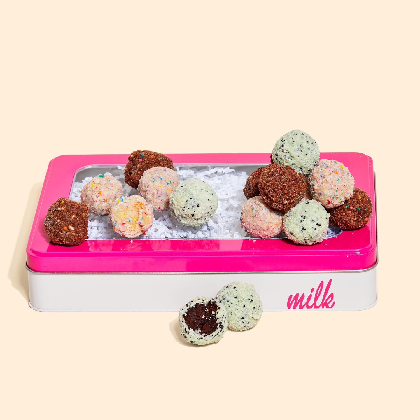 A Milk Bar branded tin with B'day Truffles, Chocolate B'day Truffles, and Chocolate Mint Chip Cake truffles on top.